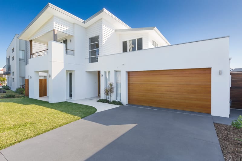 B&D Panelift Icon timber look sectional garage door on a white double storey home