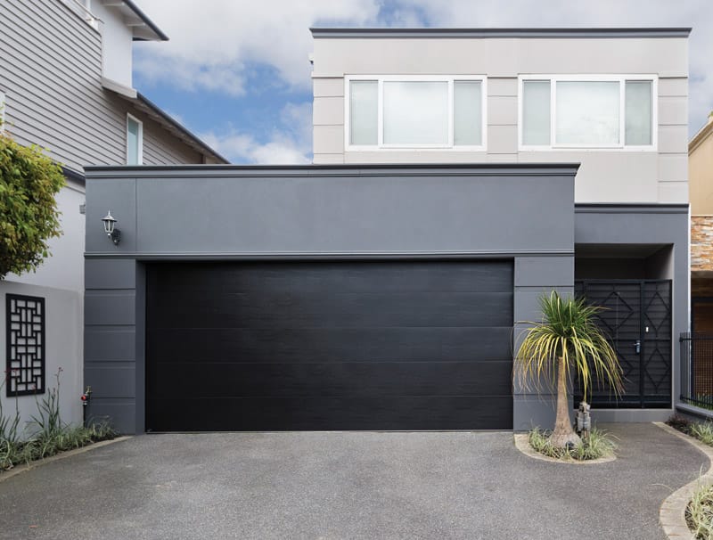 B&D Panelift sectional garage door in black on a grey rendered double storey home
