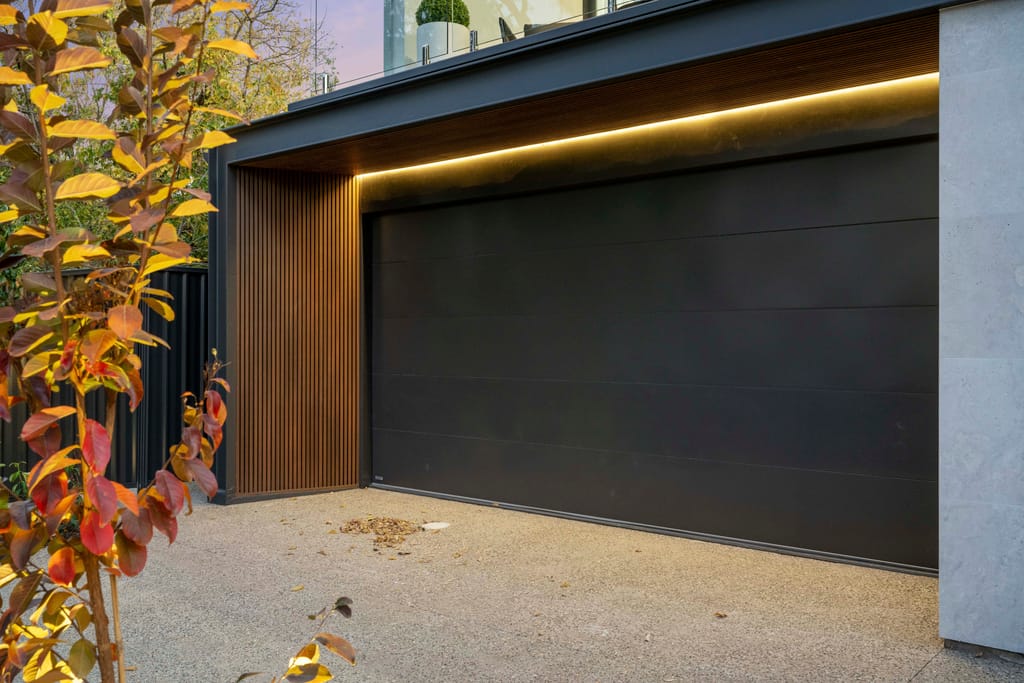 Gliderol Essential Series sectional garage door in charcoal on a modern home with timber cladding