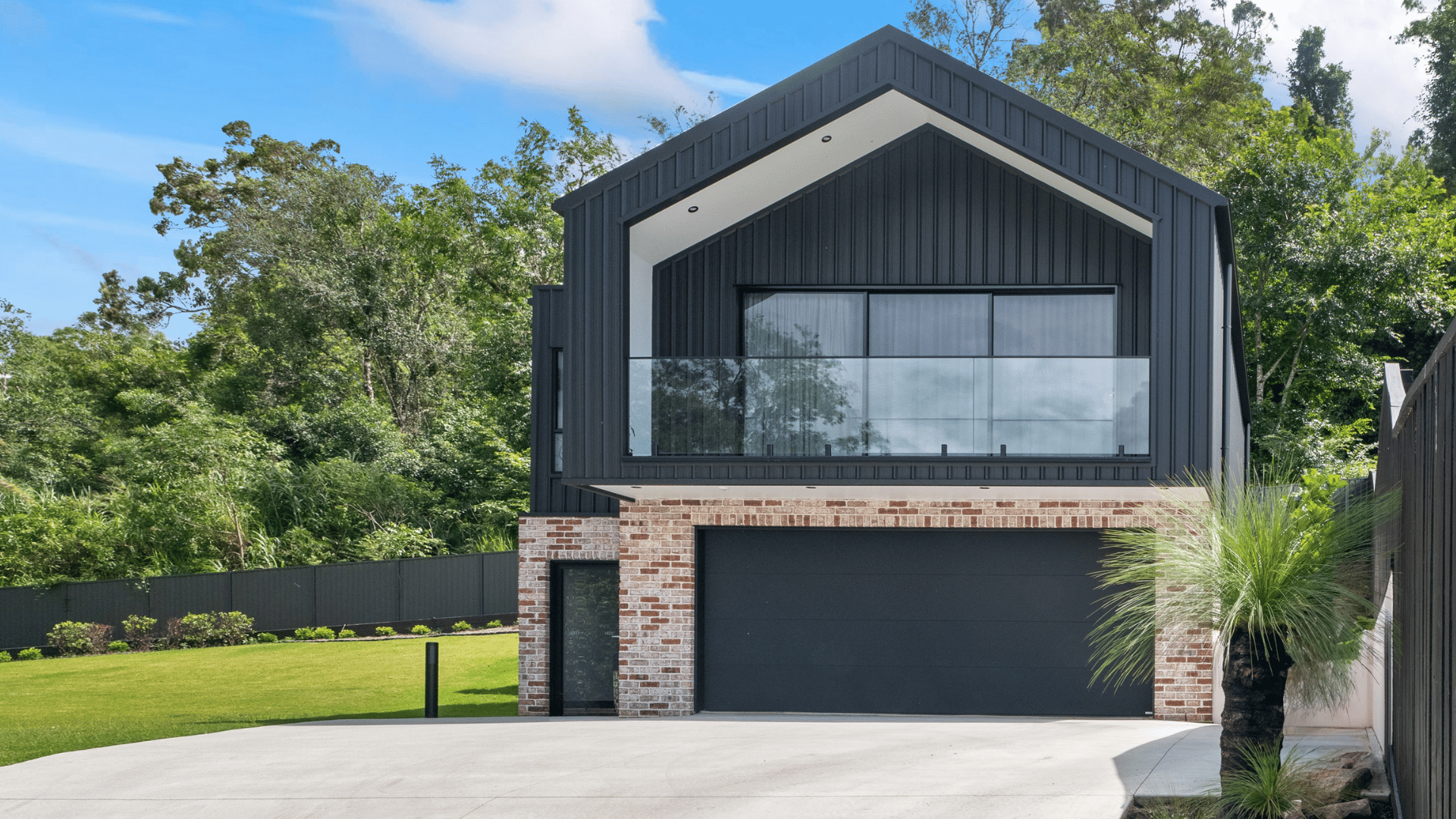 Gliderol Platinum Series sectional garage door in a dark finish on a black barn style home